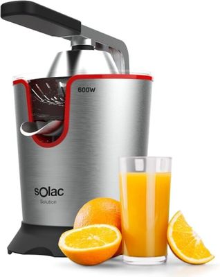 un gros plan d'un presse-agrumes à côté d'un verre de jus d'orange