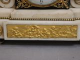 une horloge blanche et or posée sur une table