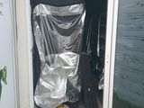 a toilet that is covered with a sheet in front of a window