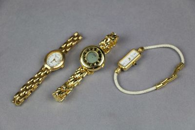 two watches and a bracelet are sitting on a table