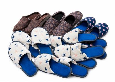 several pairs of slippers are lined up on a white surface