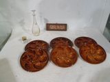 quatre assiettes en céramique brune et un vase en verre sur une table