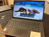 un ordinateur portable posé sur un bureau, sur lequel se trouve un bout de papier