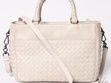 a white handbag with a braid handle and a strap