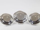three silver plated dishes on a white surface with a white background