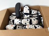 a cardboard box filled with baby shoes and a pair of scissors