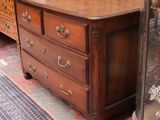 a dresser and a mirror in a room with wood paneled walls