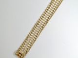 a close up of a gold bracelet on a white surface