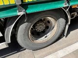 a green and yellow truck parked on the side of the road