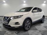Le SUV Nissan QX Sport blanc est garé dans un garage.