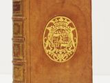 un vieux livre avec un emblème en or sur la couverture