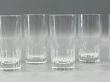six tall glasses are lined up in a row on a table