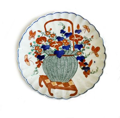 une assiette décorative sur laquelle est représenté un panier de fleurs
