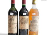 three bottles of wine sitting next to each other on a white surface