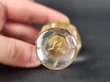 a person holding a glass bottle with a glass inside of it