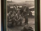 photographie en noir et blanc d'un groupe d'hommes devant un avion