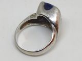 bague en argent ornée d'une pierre de lapis-lazuli posée sur un fond blanc