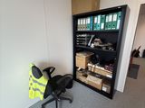 une photo d'une pièce avec une chaise et une bibliothèque