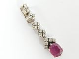 a close up of a ruby and diamond pendant on a white background