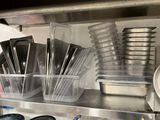 de nombreux récipients et casseroles sur l'étagère de la cuisine