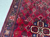a large red rug on the floor with a cross on it