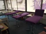 des chaises violettes dans une pièce dotée d'une grande fenêtre et d'une affiche accrochée au mur