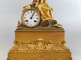 l'image d'une horloge en or sur laquelle est assise une femme