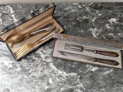 un service d'argenterie dans un coffret posé sur une table en marbre
