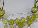 a green glass set with gold rims on a white table