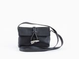 un sac en cuir noir muni d'un fermoir métallique, sur fond blanc