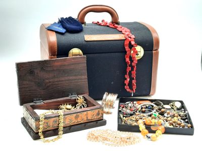 plusieurs bijoux posés sur une table à côté d'une valise