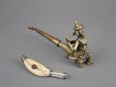 une figurine représentant un homme assis sur un tuyau, à côté d'un autre tuyau