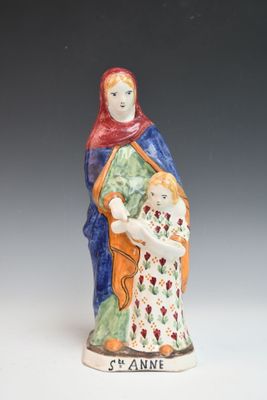 figurine d'une femme tenant un enfant dans ses bras