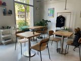 des tables et des chaises dans une pièce dotée d'une grande fenêtre et d'un porte-manteau