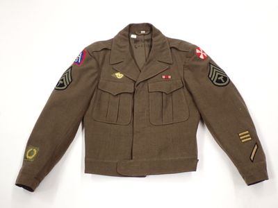 an army uniform jacket with patches on the sleeves and shoulder
