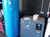 un réservoir bleu posé à côté d'une machine bleue dans une pièce