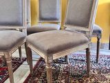quatre chaises posées sur un tapis dans une pièce