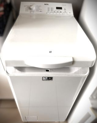 a white dishwasher sitting on top of a washer dryer
