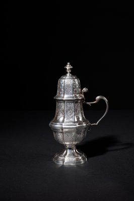 an antique silver coffee pot on a black background