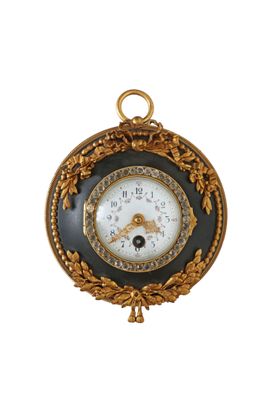 une horloge dorée et noire accrochée à un mur blanc