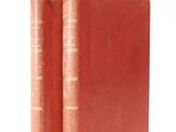 two red books sitting on top of each other on a white surface