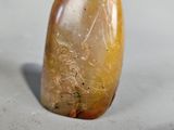 a picture of a yellow and brown stone object on a white surface