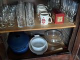 a wooden cabinet with many glasses and dishes on it