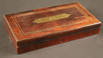 une vieille boîte en bois sur laquelle est fixée une plaque en laiton