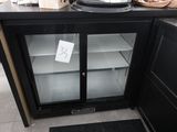 un réfrigérateur avec une porte vitrée au milieu d'une cuisine