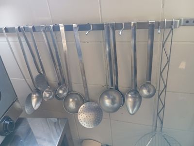 a lot of spoons hanging from the wall in the kitchen
