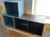 a blue and black shelf in the corner of a room