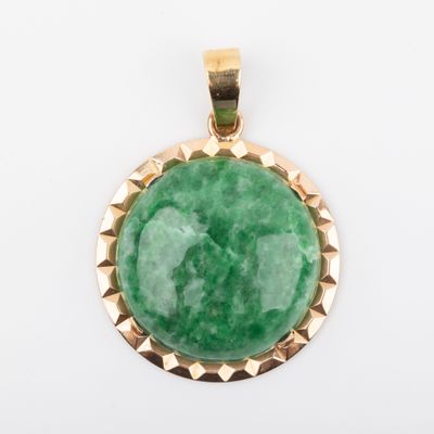 a green jade stone pendant with gold accents on a white background
