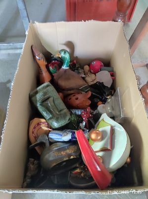 une boîte en carton remplie de jouets divers, posée par terre