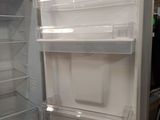 a white refrigerator with its door open in a room